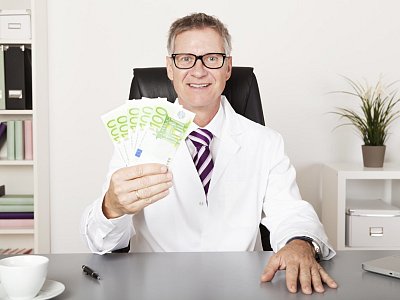 Happy Physician Holding Cash - Sebastian Gauert - stock.adobe.com